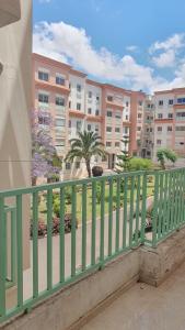 a balcony with a green railing and buildings at Sweet Room in Casa in Casablanca