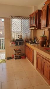 a kitchen with wooden cabinets and a tile floor at Sweet Room in Casa in Casablanca