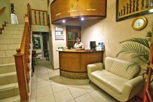 a woman sitting at a counter in a restaurant at Maximos Petit Hotel in Flores