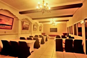 a conference room with chairs and tables and a chandelier at Maximos Petit Hotel in Flores