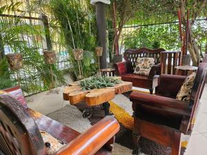 a patio with chairs and a wooden table and chairs at Maximos Petit Hotel in Flores