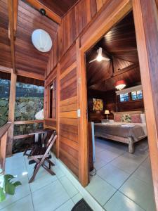 a room with wood paneled walls and a bedroom at Aratinga Inn in Abraão