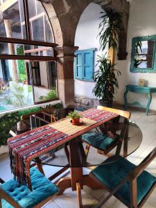 a wooden table and chairs in a room with a table at KANTIQ House in Cusco