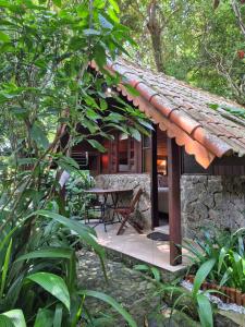 a cabin in the woods with a table in front of it at Aratinga Inn in Abraão