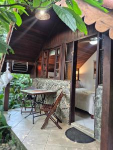 a patio with a table and a stone wall at Aratinga Inn in Abraão