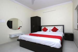 a bedroom with a large bed with red pillows at Hotel O Atithi Home Stay in Garhā