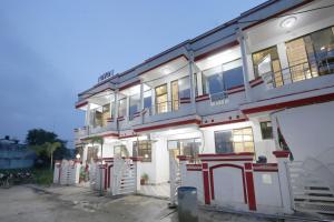a white and red building with a lot of windows at Hotel O Atithi Home Stay in Garhā