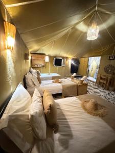 a bedroom with two beds in a tent at Morocco desert camp in Merzouga