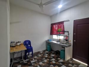 a small kitchen with a table and a blue chair at BLISS HomeStay in Sipitang