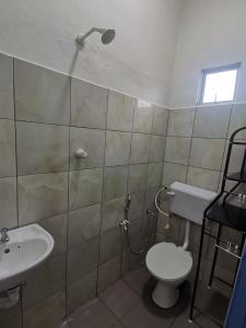 a bathroom with a toilet and a sink at BLISS HomeStay in Sipitang