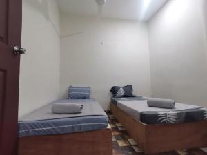 two beds are sitting in a room withthritisthritisthritisthritisthritisthritisthritisthritis at BLISS HomeStay in Sipitang