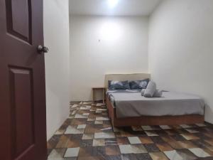 a bedroom with a bed and a tiled floor at BLISS HomeStay in Sipitang