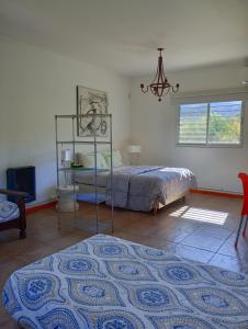 a bedroom with a bed and a table and a window at Loft Las Acacias in Potrero de los Funes