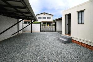a courtyard of a house with a gate and a building at Container Loft Com Área de Churrasqueira Privativa in Piçarras