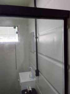 a bathroom with a toilet and a window and a sink at Container Loft Com Área de Churrasqueira Privativa in Piçarras +9 photos