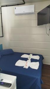 a room with a bed with towels on it at Container Loft Com Área de Churrasqueira Privativa in Piçarras