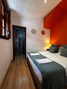 a bedroom with a large bed with an orange wall at Best House Center - with Garage in Porto