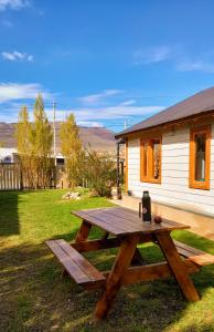 a wooden picnic table in front of a house at Cabaña Meely in El Calafate