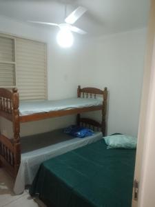 two bunk beds in a room with a ceiling at Ap Simples arc, bem localizado confortável e aconchegante, 2 quartos in Araçatuba