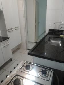 a kitchen with a stove and a counter top at Ap Simples arc, bem localizado confortável e aconchegante, 2 quartos in Araçatuba +15 photos