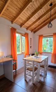 a dining room with a table and orange curtains at Cabaña Meely in El Calafate