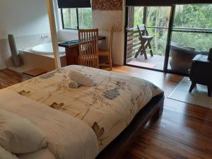a bedroom with a bed and a bathroom with a tub at Alaya Ascend in Eudlo +159 photos