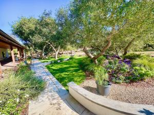 a garden with trees and plants and a sidewalk at Wranglers Rest Ranch in Arroyo Grande
