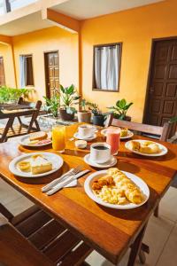 a wooden table topped with plates of breakfast food at Tapirandú Pousada in Morro de São Paulo