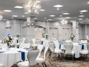 a banquet room with white tables and chairs and chandeliers at Ashworth by the Sea in Hampton +50 photos