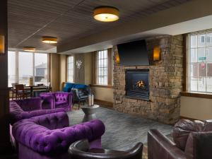 a lobby with purple furniture and a stone fireplace at Ashworth by the Sea in Hampton