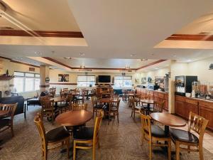 a restaurant with wooden tables and chairs and a bar at Yellowstone Lodge in West Yellowstone