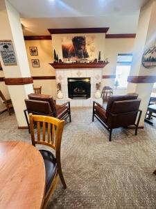 a living room with chairs and a fireplace at Yellowstone Lodge in West Yellowstone