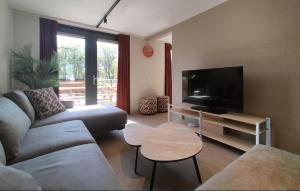 a living room with a couch and a flat screen tv at 5 Bedroom Luxurious Home In Afferden in Afferden