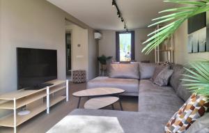 a living room with a couch and a flat screen tv at 5 Bedroom Luxurious Home In Afferden in Afferden