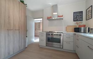 a kitchen with white cabinets and a stainless steel oven at 5 Bedroom Luxurious Home In Afferden in Afferden