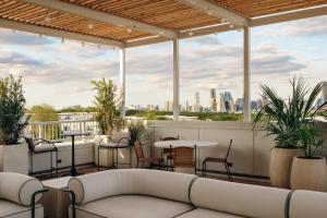 a rooftop patio with a couch and tables and chairs at The Code Hotel in Austin
