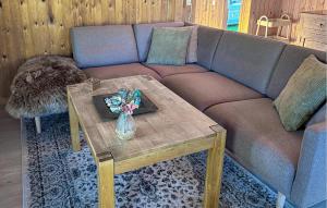 a couch with a table and a vase with flowers on it at 3 Bedroom Nice Home In Farsø in Farsø