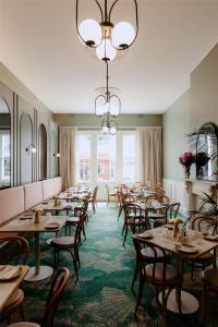 a dining room with tables and chairs and a chandelier at Ramsgate Hotel by Nightcap Social in Adelaide