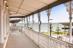 a balcony with a view of the ocean at Ramsgate Hotel by Nightcap Social in Adelaide