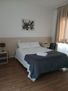 a bedroom with a bed with two towels on it at Flat Lagoa Santa in Lagoa Santa