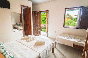 a room with two beds and a mirror at Tapirandú Pousada in Morro de São Paulo