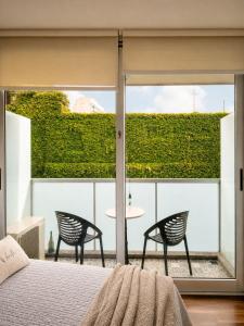 a bedroom with a bed and two chairs and a patio at Lezama Park ll in Buenos Aires +12 photos