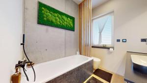 a bathroom with a bath tub and a sink at Vila Golf & Relax, Hrubá Borša in Hrubá Borša +17 photos