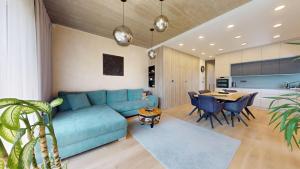 a living room with a blue couch and a table at Vila Golf & Relax, Hrubá Borša in Hrubá Borša