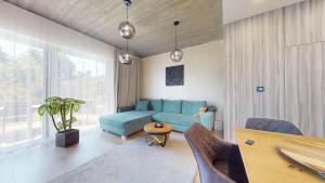 a living room with a blue couch and a table at Vila Golf & Relax, Hrubá Borša in Hrubá Borša