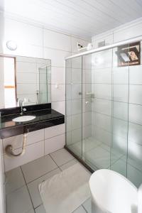 a bathroom with a glass shower and a sink at Tapirandú Pousada in Morro de São Paulo