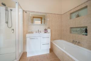 a bathroom with a white tub and a sink and a bath tub at Jones On Wilson Boutique B&B in Burnie +13 photos