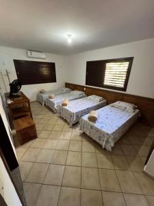 a room with three beds and a table and a window at Casa Brisa do Mar in Pipa +16 photos