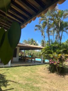 a view of a resort with a picnic table and palm trees at Casa Brisa do Mar in Pipa