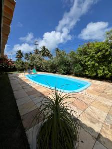a large blue swimming pool in a yard at Casa Brisa do Mar in Pipa